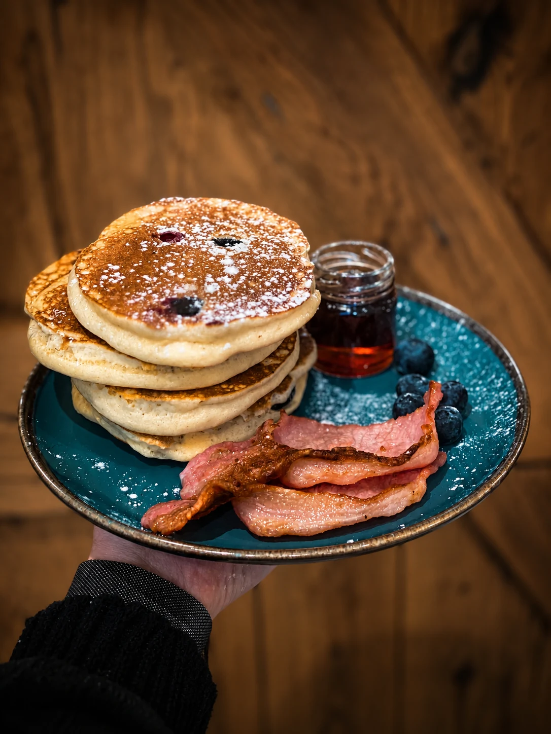 Blueberry pancakes served with bacon and syrup