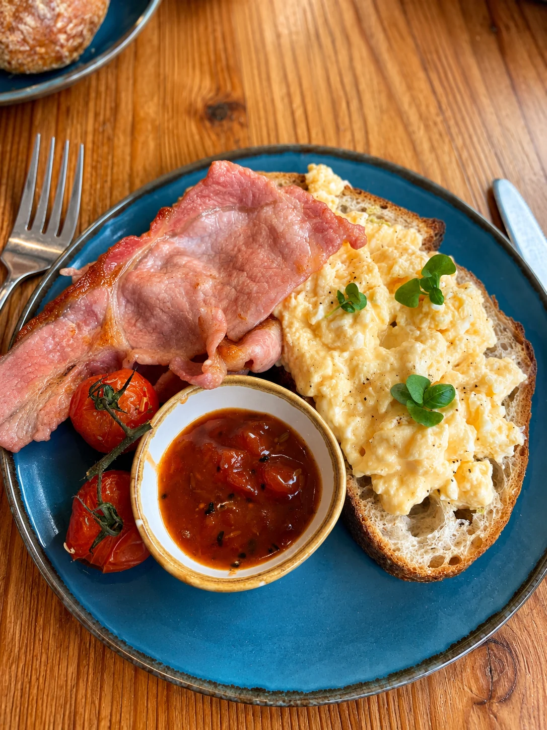 Scrambled eggs, bacon and tomatoes served on toast