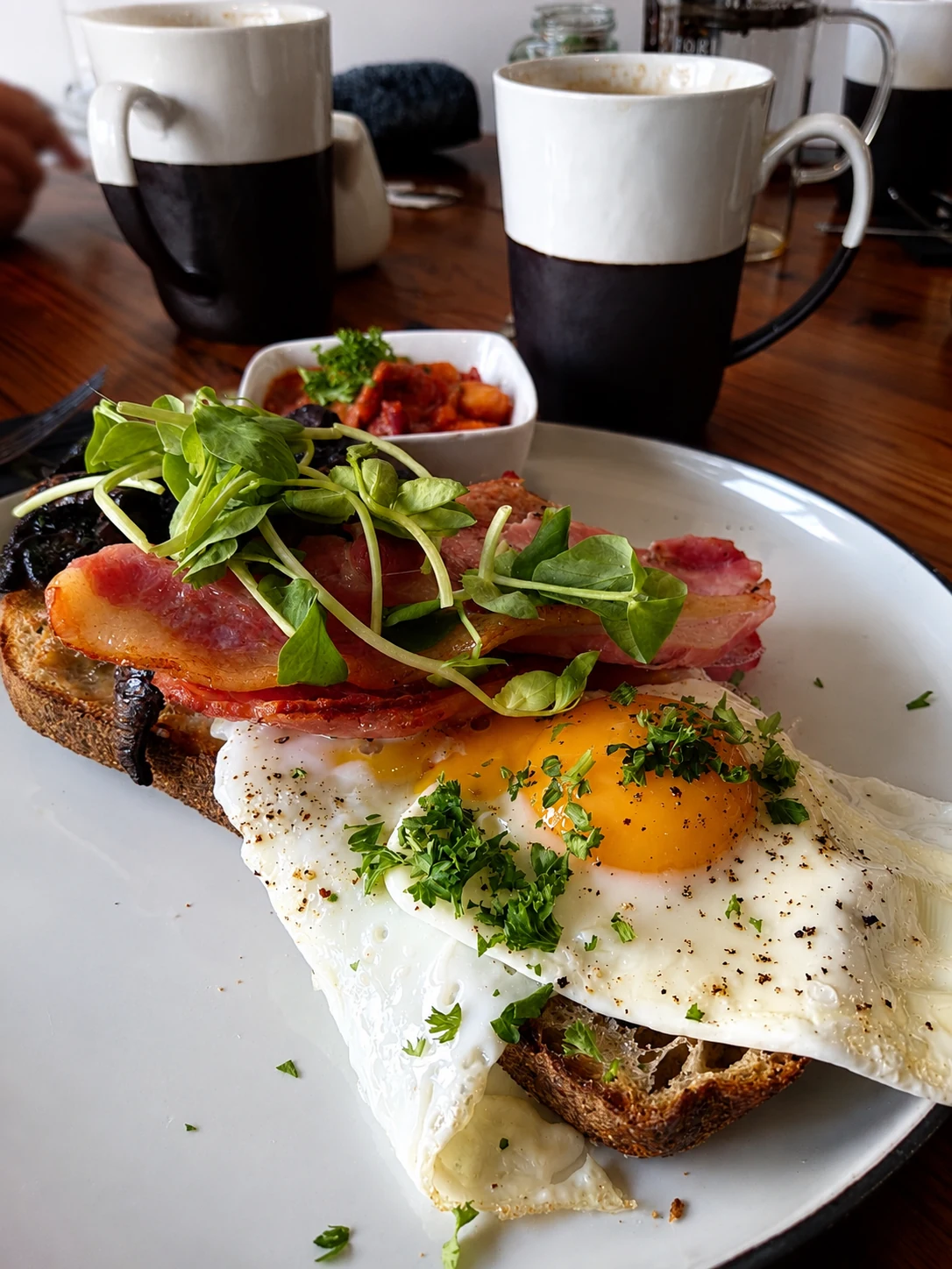 Fried eggs and bacon on toast with coffee at the table